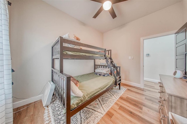 bedroom featuring light wood-style flooring, baseboards, and a ceiling fan