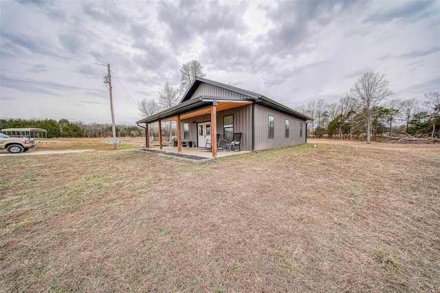 rear view of property with a patio and a lawn