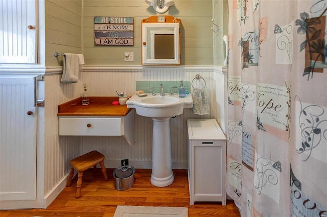 full bathroom with a sink and wood finished floors