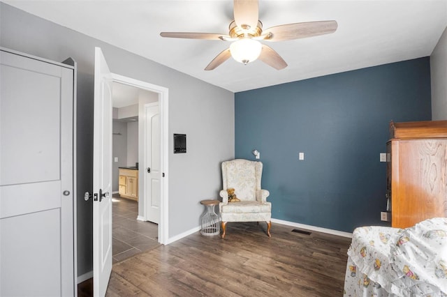 sitting room with visible vents, ceiling fan, baseboards, and wood finished floors