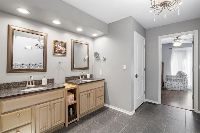 full bath with recessed lighting, two vanities, a sink, and baseboards