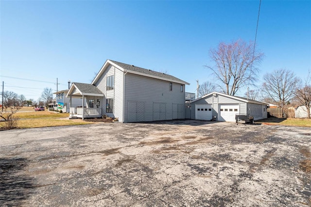 view of home's exterior with a garage, a yard, and an outdoor structure