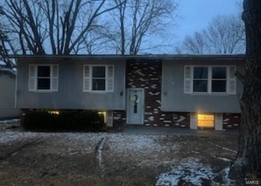 split foyer home featuring a garage and dirt driveway