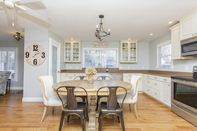 dining area with recessed lighting, light wood-style flooring, baseboards, and an inviting chandelier