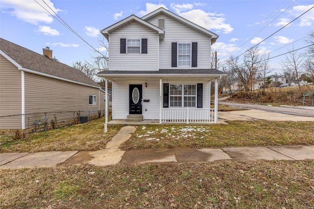 traditional home with covered porch and fence