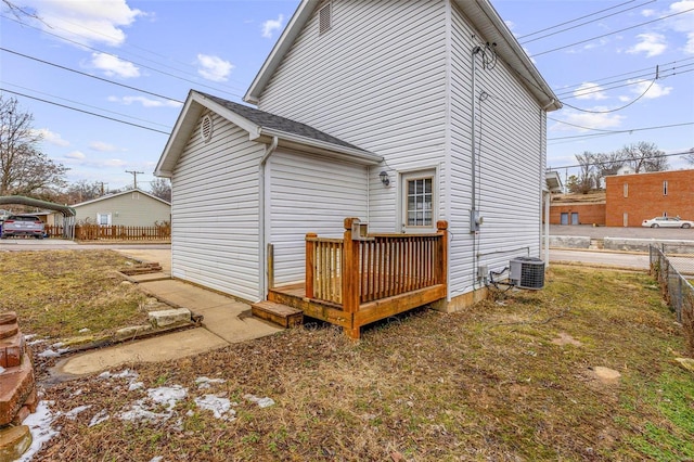 back of property featuring a detached carport, central AC, fence, and a wooden deck