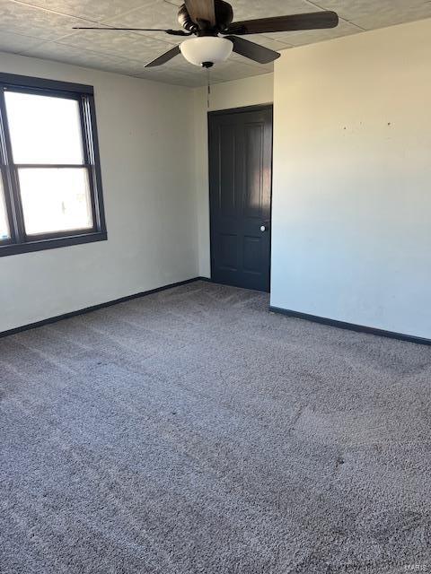 spare room featuring carpet floors, baseboards, and a ceiling fan