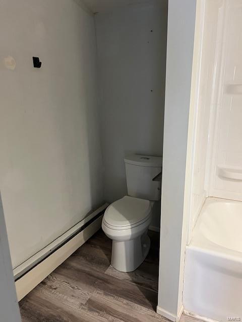 bathroom with a baseboard radiator, toilet, and wood finished floors