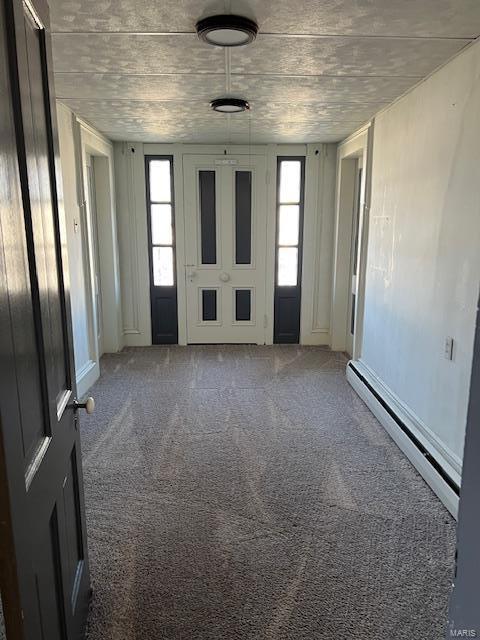 carpeted empty room featuring a baseboard radiator