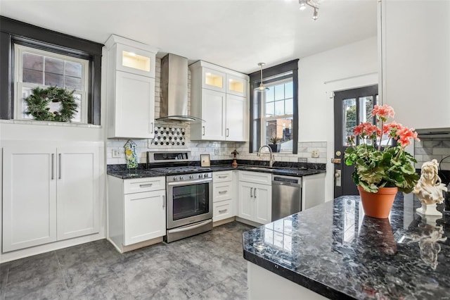 kitchen with wall chimney exhaust hood, appliances with stainless steel finishes, and white cabinetry