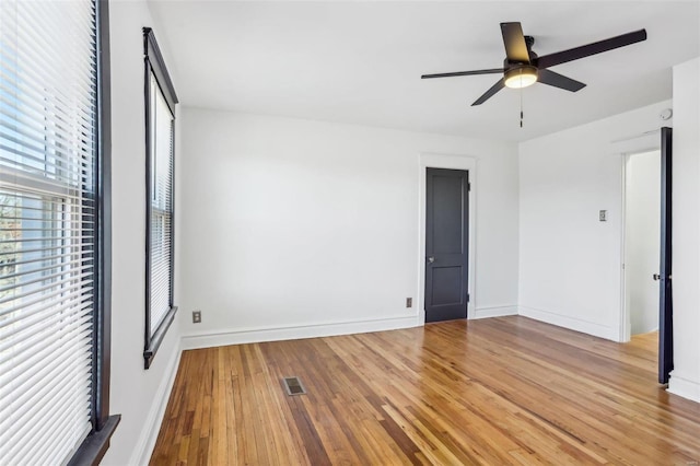 unfurnished bedroom featuring a ceiling fan, wood finished floors, visible vents, and baseboards