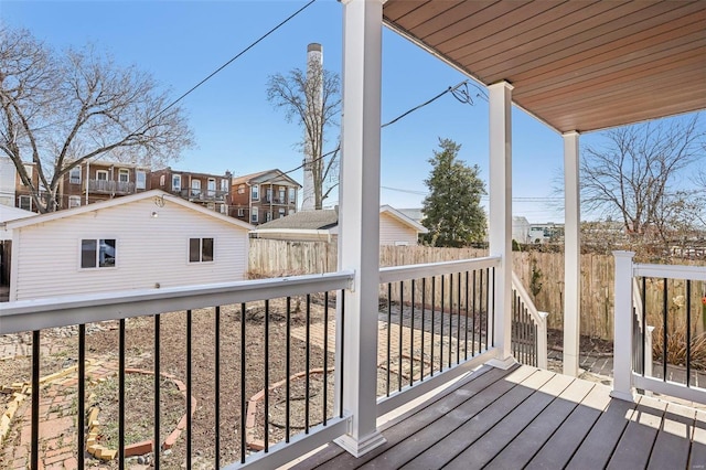 wooden terrace featuring an outbuilding and fence