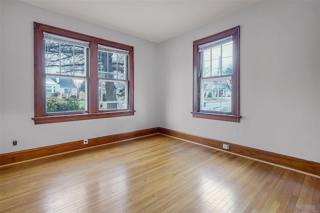 spare room with light wood finished floors and baseboards