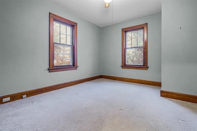 carpeted spare room featuring baseboards