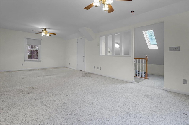 unfurnished living room with ceiling fan, speckled floor, plenty of natural light, and a skylight