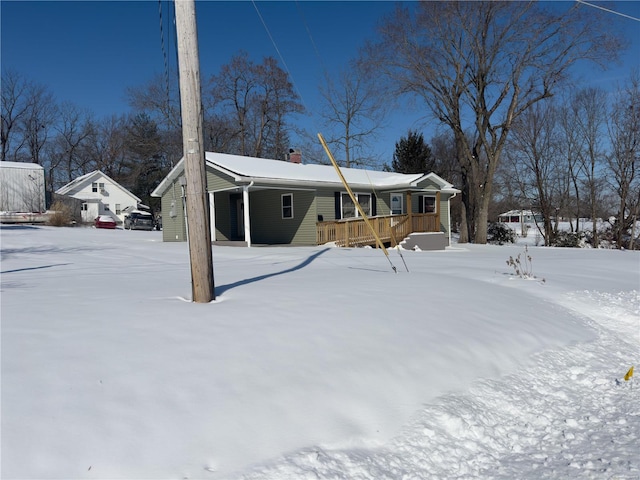 view of front of home featuring a chimney, an attached carport, and a porch