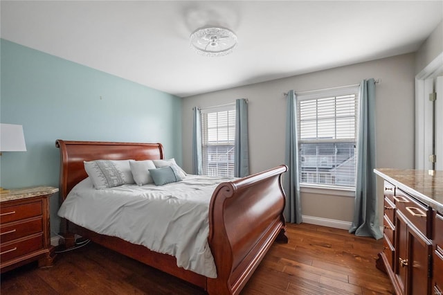 bedroom with dark wood-type flooring and baseboards