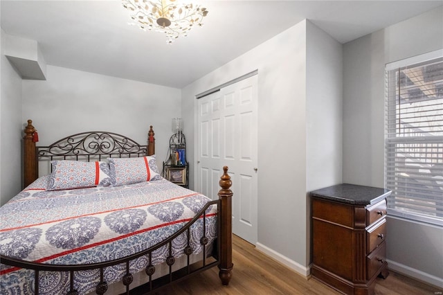 bedroom with a closet, baseboards, and wood finished floors