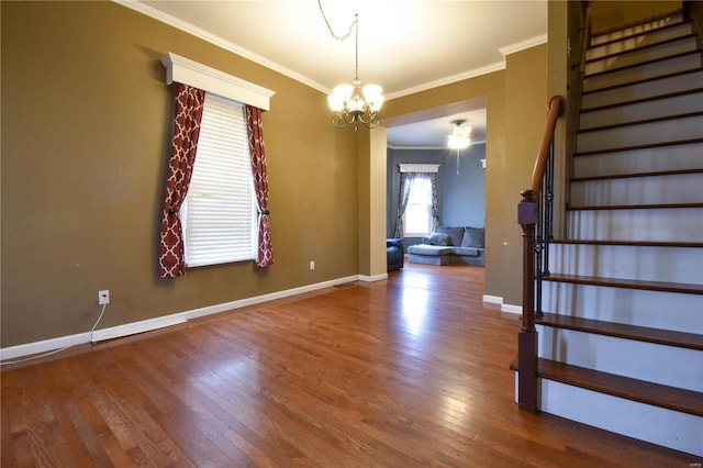 interior space featuring crown molding, hardwood / wood-style floors, an inviting chandelier, baseboards, and stairs