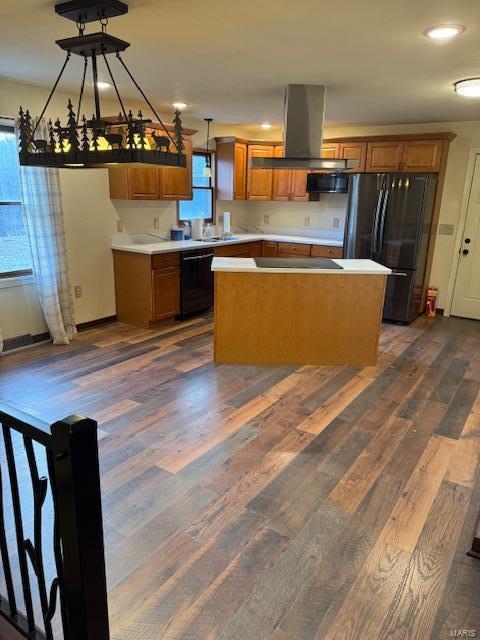 kitchen featuring dark wood-style floors, brown cabinetry, a kitchen island, island range hood, and black appliances