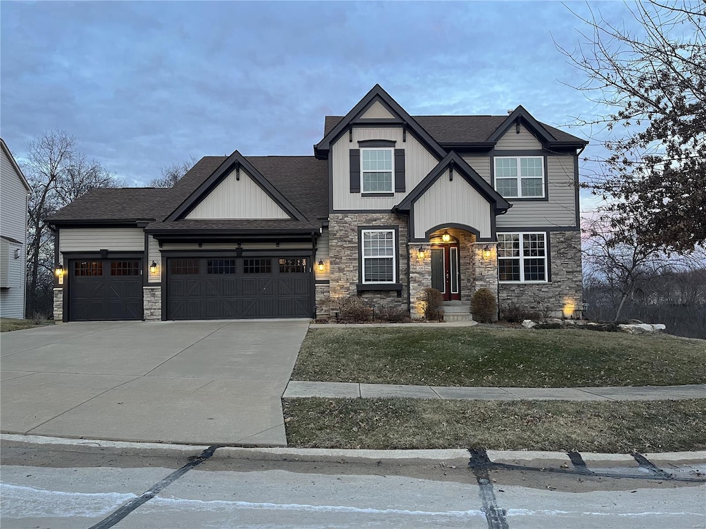 craftsman-style home featuring a garage, a shingled roof, concrete driveway, and a front yard