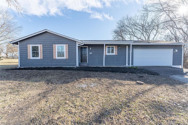 ranch-style house featuring a garage and dirt driveway