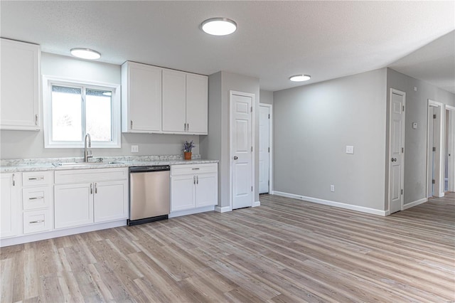 kitchen featuring a sink, baseboards, white cabinets, stainless steel dishwasher, and light wood finished floors