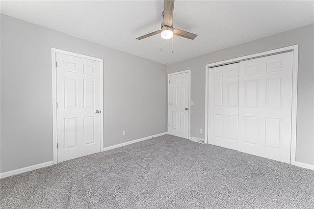 unfurnished bedroom featuring visible vents, baseboards, ceiling fan, carpet, and a closet