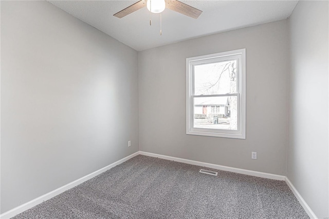 unfurnished room featuring ceiling fan, carpet floors, visible vents, and baseboards