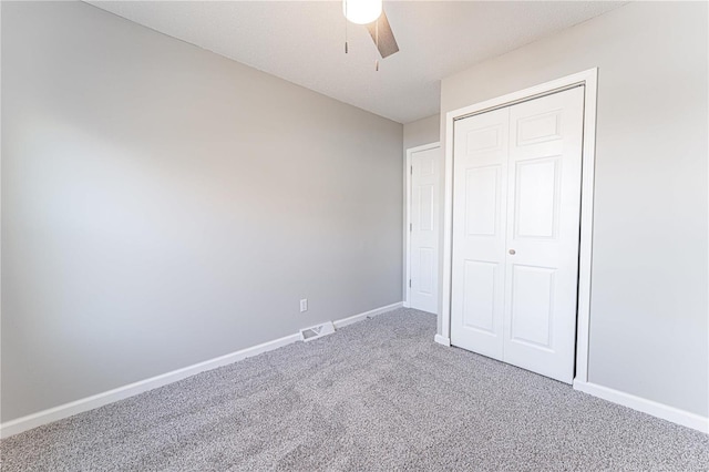 unfurnished bedroom with visible vents, a closet, baseboards, and carpet flooring