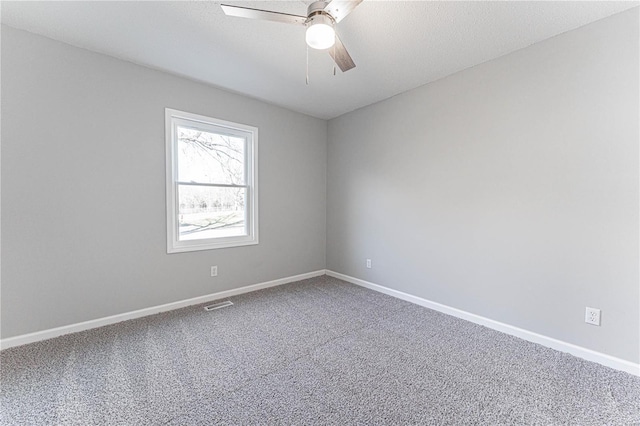 carpeted spare room with a textured ceiling, baseboards, and a ceiling fan