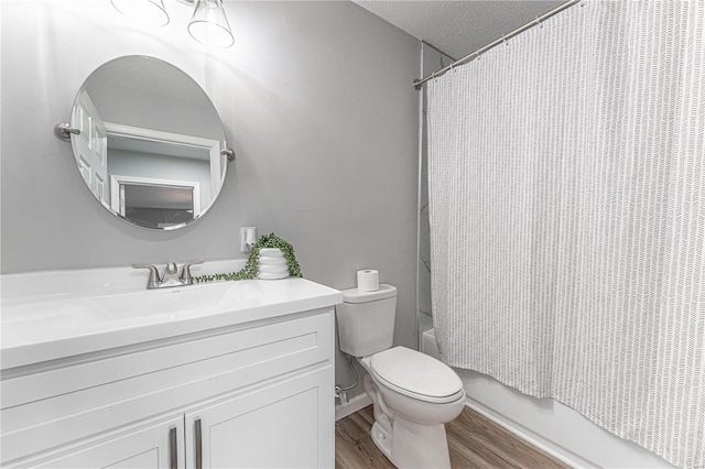 full bath featuring a textured ceiling, toilet, wood finished floors, vanity, and shower / bath combo