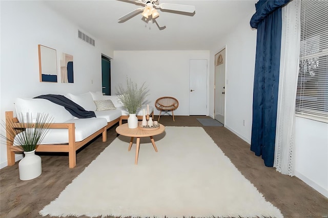 living area featuring carpet flooring, visible vents, and a ceiling fan