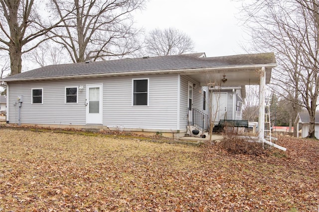 back of property with entry steps and roof with shingles