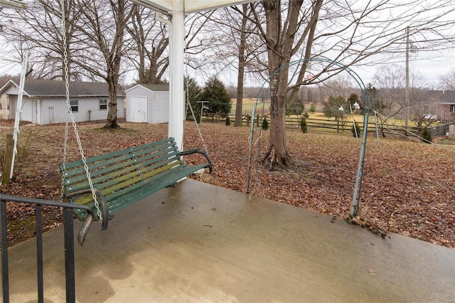 view of yard with a storage shed, an outbuilding, and fence