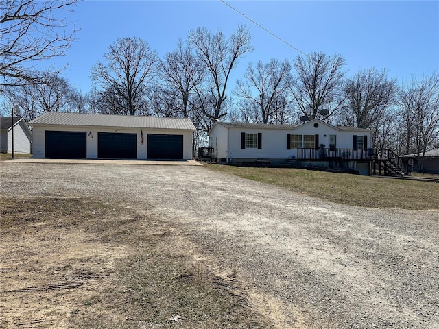 view of front of house featuring a garage and an outbuilding