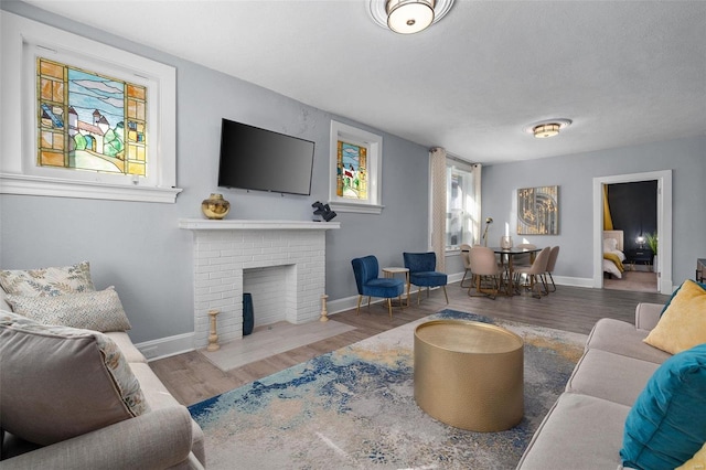 living area with dark wood-style floors, a fireplace, and baseboards