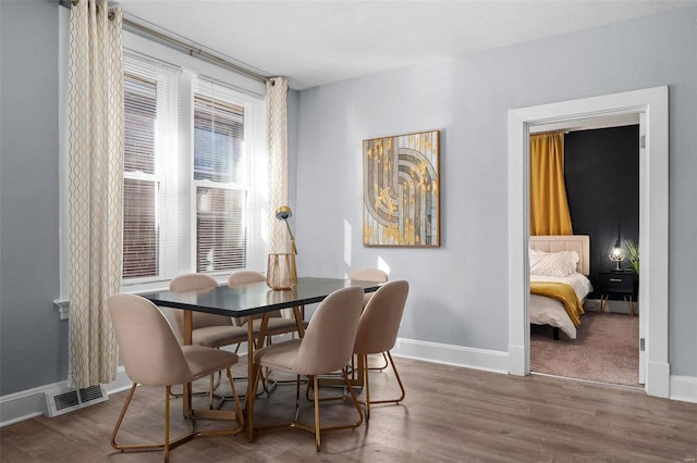 dining room with baseboards, visible vents, and dark wood-style flooring