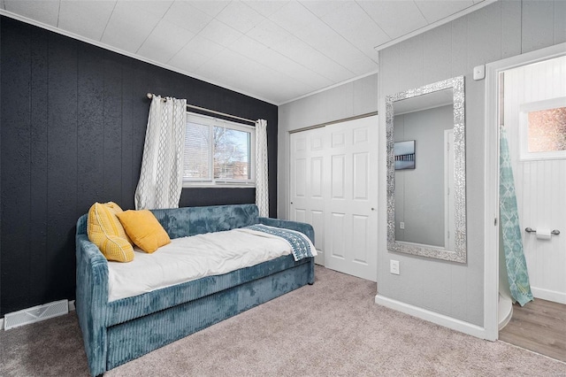 carpeted bedroom featuring ornamental molding, a closet, visible vents, and multiple windows