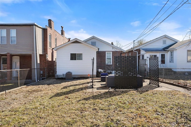 rear view of house featuring a yard, an outdoor hangout area, a patio area, central AC, and a fenced backyard