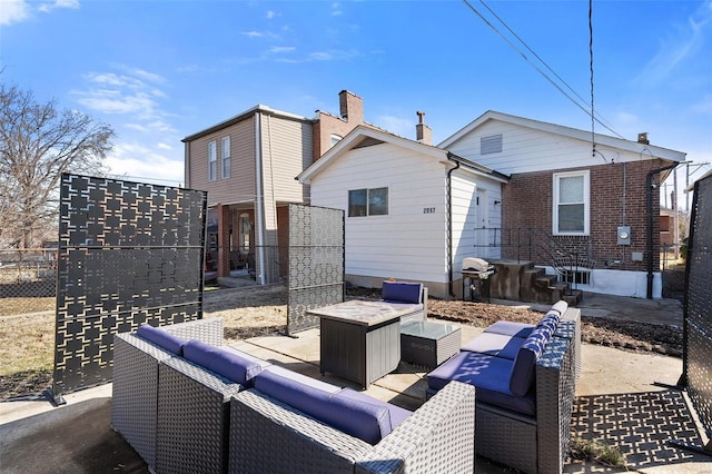 rear view of house with an outdoor living space with a fire pit