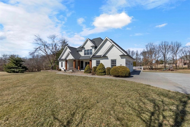 view of front of property featuring a garage, driveway, and a front lawn