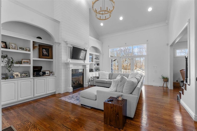 living area featuring baseboards, built in features, a glass covered fireplace, dark wood-type flooring, and high vaulted ceiling