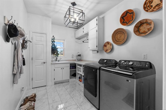 washroom featuring cabinet space, marble finish floor, washer and dryer, a chandelier, and a sink