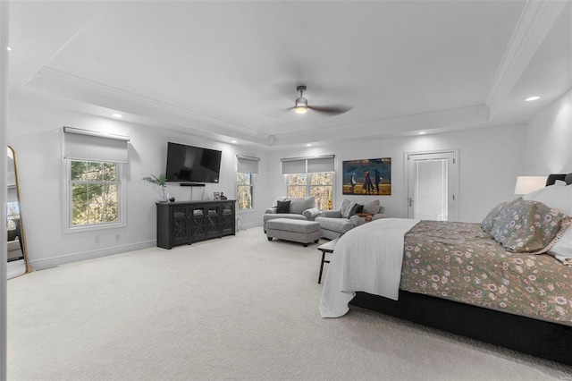 bedroom with a raised ceiling, carpet flooring, crown molding, and multiple windows