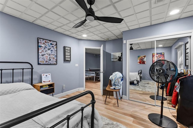 bedroom featuring light wood finished floors, a closet, a ceiling fan, and baseboards