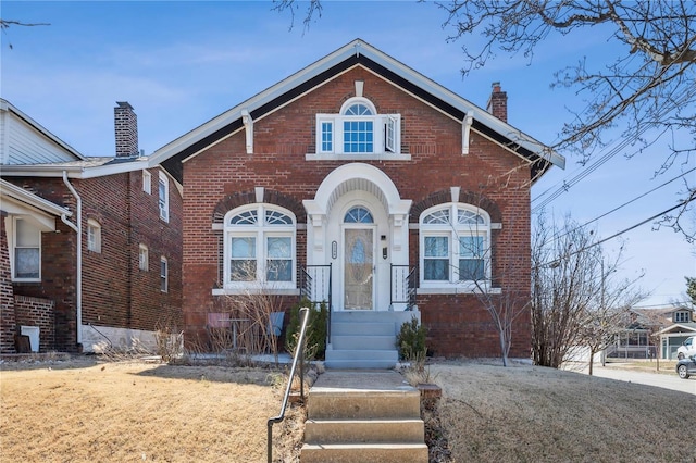 view of front of home with brick siding and a chimney