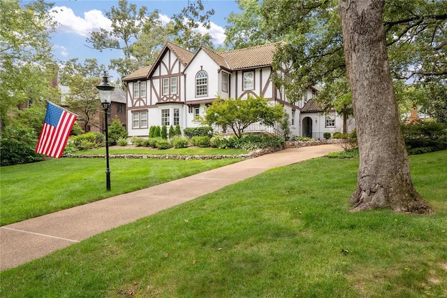 tudor home with a front yard and stucco siding