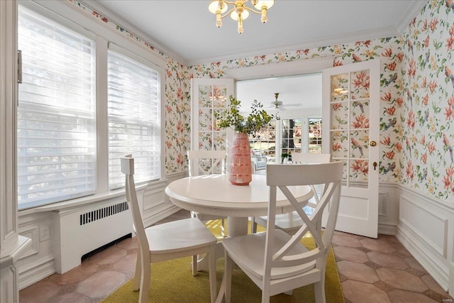 dining area with wallpapered walls, radiator heating unit, plenty of natural light, and a wainscoted wall