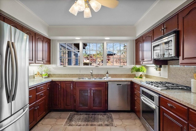 kitchen with a sink, dark brown cabinets, appliances with stainless steel finishes, tasteful backsplash, and crown molding